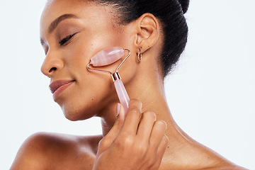 Image showing Facial roller, beauty and face of a woman in studio for dermatology, cosmetics and natural skin. Aesthetic model person with facial massage tools for healthy glow isolated on a white background