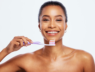 Image showing Portrait, dental and a black woman brushing teeth in studio isolated on a white background for oral hygiene. Face, toothbrush and toothpaste with an attractive young female posing on blank space