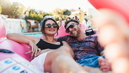 Image showing Couple, relax and smile for pool party on inflatable floating in the water enjoying summer vacation together. Happy man and woman relaxing in swimming pool on floaty with sunglasses for holiday break