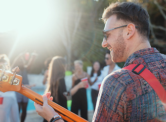 Image showing Guitar, music and party with a man outdoor at a celebration playing a song as a musician or artist. Happy, fun and performance with a male guitarist holding an instrument to perform at a birthday