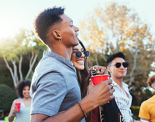 Image showing Drinks, party and a couple of friends outdoor to celebrate at festival, concert or summer social event. Diversity young men and women crowd while happy, hug and drinking alcohol while listening