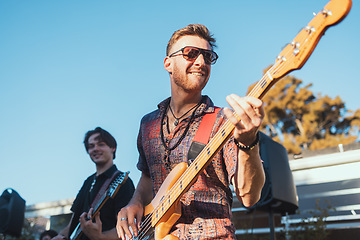 Image showing Guitar, music and party with a band outdoor at a celebration playing a song as a musician or artist. Happy, fun and performance with a man guitarist holding an instrument to perform at a birthday