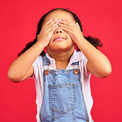 Image showing Little girl, hands and eyes cover on isolated red background for shy, mistake expression and peekaboo games. Child, kid and youth in hide and seek activity, surprise gesture or blind emoji on studio