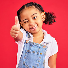 Image showing Thumbs up, portrait and girl child in studio, red background or isolated hand sign. Happy kids, thumb gesture and wink face of like emoji, support and vote of trust, thanks or yes agreement of review