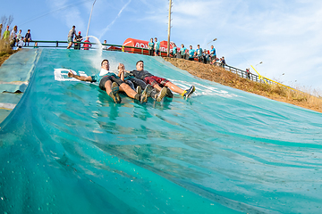 Image showing Athletes sliding to mud and water