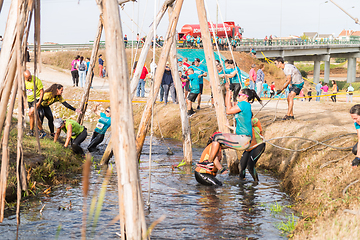 Image showing Athletes go through mud and water