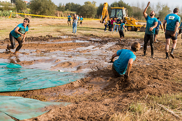 Image showing Athletes sliding to mud and water