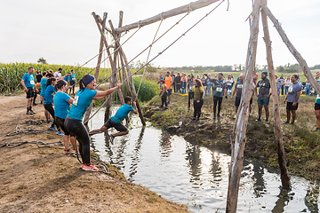 Image showing Athletes go through mud and water