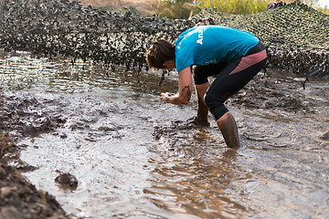 Image showing Athletes crawling through mud