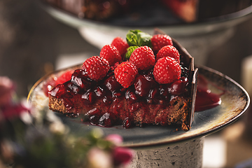 Image showing Slice of chocolate cake with cherry sauce