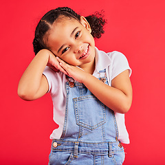 Image showing Happy, smile and cute young girl child portrait with red studio background with happiness. Smiling, youth and kid model with denim and adorable hands feeling girly, joyful and positive with fashion