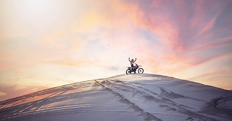 Image showing Desert, sunset and man riding a motorcycle for exercise, fitness or skill training in nature. Extreme sports, dusk and male athlete on a bike for an outdoor evening workout in the sand dunes in Dubai