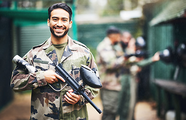 Image showing Paintball, gun and portrait of a man soldier in a camouflage military outfit for extreme sports. Happy, smile and male player in army clothes with a pistol preparing for a match in an outdoor arena.