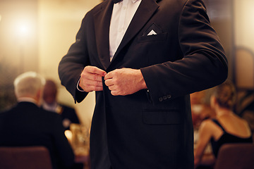 Image showing Suit, formal and man tie the button of his jacket at a fancy dinner, party or event banquet. Classy, elegance and male fixing blazer of his elegant outfit at classic supper, celebration or gathering.