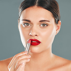 Image showing Apply lipstick, woman and face in portrait with lips, red makeup and beauty isolated on studio background. Cosmetic product, skin and skincare glow with wellness, facial with cosmetics shine