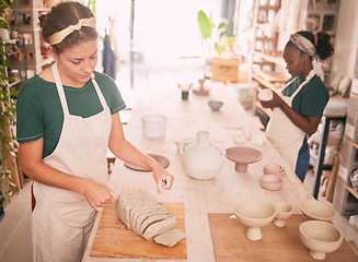 Image showing Pottery workshop and woman dividing clay for sculpting process and productivity at creative business. Focus, concentration and skill of interracial artist team working in professional workspace.