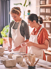 Image showing Pottery, ceramic and teacher with student in workshop training, learning and sculpture class production. Clay design, mentor and creative women or artist working together on mold for industry process