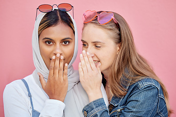 Image showing Woman, friends and secret whisper of gossip in shock against a pink studio background. Women sharing secrets, rumor or surprise whispering in the ears for hidden story, sale or discount announcement