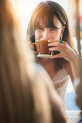 Image showing Woman, friends and drinking coffee for conversation, chatting about social life or gossip at an outdoor cafe. Happy female smiling and enjoying a warm beverage, discussion or listening to best friend