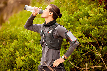 Image showing Man, runner fitness and drinking water outdoor for hike, cardio training or exercise workout. Athlete, sports break with bottle drink and sports wellness running in nature park or mountain hiking