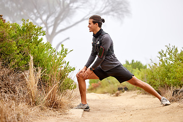 Image showing Stretching legs, running and man on nature trail for fitness, marathon training and cardio workout outdoors. Sports, body performance and happy male athlete warm up for wellness, exercise and balance