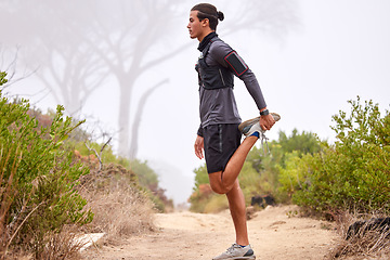 Image showing Fitness, stretching legs and man on nature trail for running, marathon training and cardio workout outdoors. Sports, healthy body and focused male athlete warm up for wellness, exercise and hiking