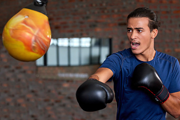 Image showing Gym fitness and boxer man punch for sports workout, training and athlete practice with equipment. Energy, focus and power of young martial arts fighter guy at kickboxing and wellness club.