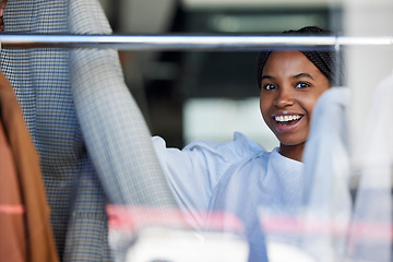 Image showing Shopping, clothes and face of black woman in store with choice on rack for sale, discount and promotion. Fashion, designer boutique and happy girl customer with clothing, outfit and retail products