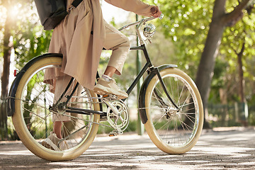 Image showing Bicycle, closeup and feet of casual cyclist travel on a bike in a park outdoors in nature for a ride or commuting. Exercise, wellness and lifestyle student cycling as sustainable transport