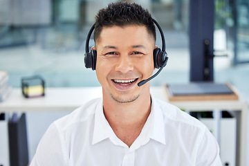 Image showing CRM, portrait and Asian customer service employee happy to be working telemarketing in the office. Support, help and man agent, consultant or worker smiling on an online video call using a headset