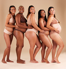 Image showing Portrait, pregnant and happy women in row on studio background in community, diversity or baby support group. Smile, happy or bonding mothers with pregnancy stomach, underwear or healthcare wellness