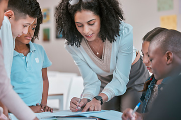 Image showing African teacher teaching children, helping students in classroom with homework and writing in book. Diversity in education, educator reading kids notebook and group learning together for assessment