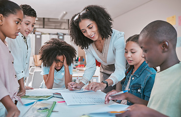 Image showing Female teacher helping children with assignment, classroom in school and writing notes in book. Diversity in student group, educator reading kids notebook and learning together for assessment