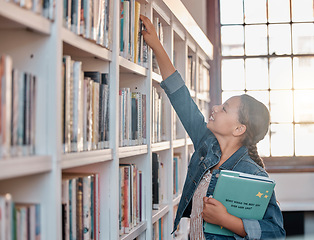 Image showing Books, education or child in a library to search for knowledge or development for future learning. Hand reaching, student growth or happy girl studying, information or searching for a story at school