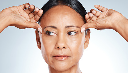 Image showing Skincare, beauty and senior woman thinking of wrinkles isolated on a grey studio background. Worry, cosmetic and face of a mature model feeling skin for anti aging, concern and idea on a backdrop