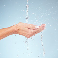 Image showing Senior hands, water splash for clean hygiene, fresh sustainability or wash against studio background. Hand of elderly holding natural liquid drops for skin hydration, wellness or safety from bacteria