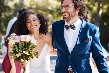 Image showing Wedding, happy couple and walking outdoor for marriage celebration event for bride and groom. Married interracial man and woman at ceremony with trust, partnership and a smile with flower bouquet