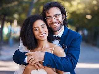 Image showing Happy, couple portrait and outdoor for wedding celebration event with a hug for commitment. Interracial man and woman at park with trust, partnership and love in marriage with support and care