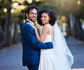 Image showing Couple portrait, wedding and interracial love outdoor for marriage celebration event together with care. Happy married man and woman at park with trust, partnership and hug for happiness and security