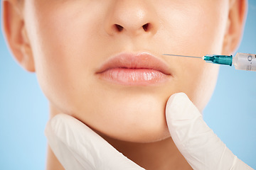 Image showing Botox, facial and lip filler by woman with cosmetic injection isolated against a studio blue background. Beauty, beauty and closeup of girl get plastic surgery at a cosmetology clinic using a syringe