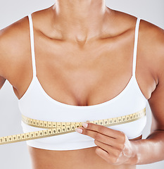 Image showing Chest, measure tape and woman isolated on white background for breast cosmetics, plastic surgery and lose weight. Liposuction, health or wellness person or model with boobs for beauty results in zoom