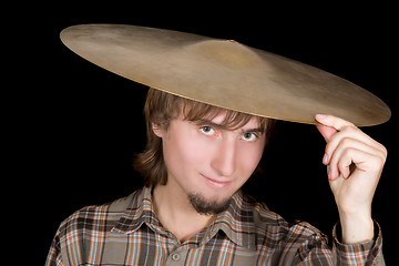 Image showing The young man with a plate from a drum on a head