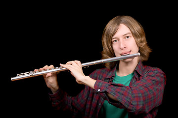 Image showing The young man plays a flute over black