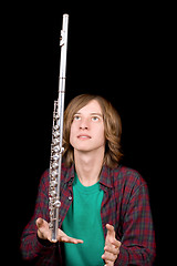 Image showing The young man plays with a flute