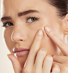 Image showing Portrait, hands and pimple with a woman checking or examining her skin for acne problems in studio. Face, fingers and breakout with an attractive young female indoor to squeeze or pop a blackhead