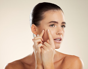 Image showing Face, hands and blackhead with a woman checking or examining her skin for acne problems in studio. Facial, fingers and breakout with an attractive young female indoor to squeeze or pop a pimple