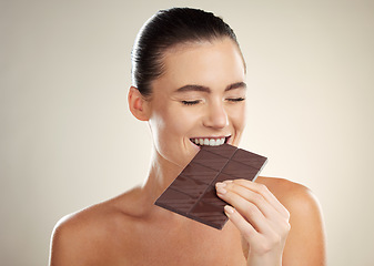 Image showing Beauty, eating and face of woman with chocolate bar, junk food or dessert for sugar sweets, candy snack or cheat meal. Cosmetics makeup, skincare and hungry model with cacao product for antioxidants