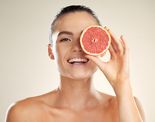 Image showing Beauty, skincare and grapefruit for portrait of a woman with natural skin dermatology product. Vitamin c fruit on face aesthetic model in studio for sustainable cosmetics for health and wellness