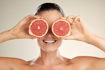 Image showing Beauty, skincare and woman cover grapefruit for natural skin dermatology or cosmetic product. Vitamin c fruit on happy face aesthetic model in studio for sustainable self care for health and wellness