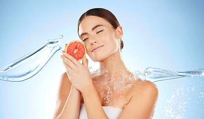 Image showing Beauty, skincare and woman with grapefruit and water for natural skin dermatology. Clean splash and face of aesthetic model in studio for sustainable fruit self care for health and spa wellness